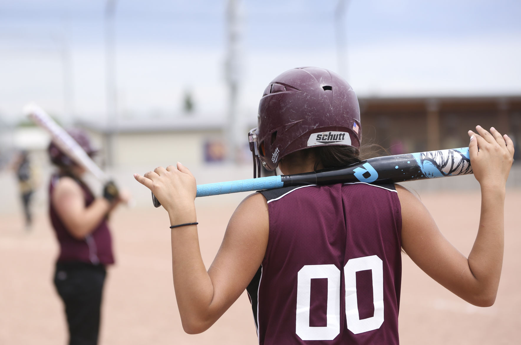 Gabby Hall rests her bat on her shoulders before beginning her practice swings